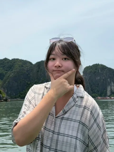 卉珣站在海灣前，背後是石灰岩小島。